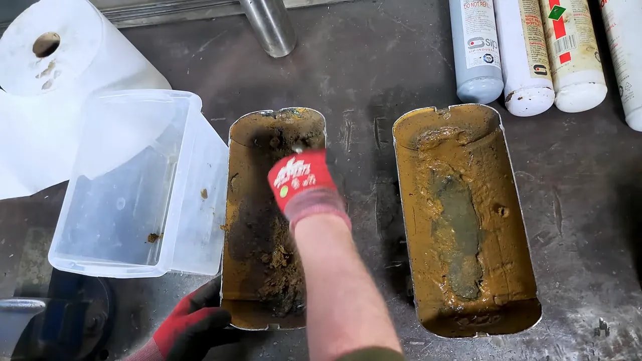 Close view of corroded compressor tank interior showing pitting and rusty residue