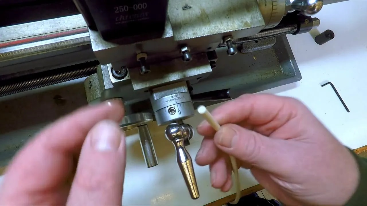Close-up of mini lathe friction dial adjustment with plug and dial collar visible