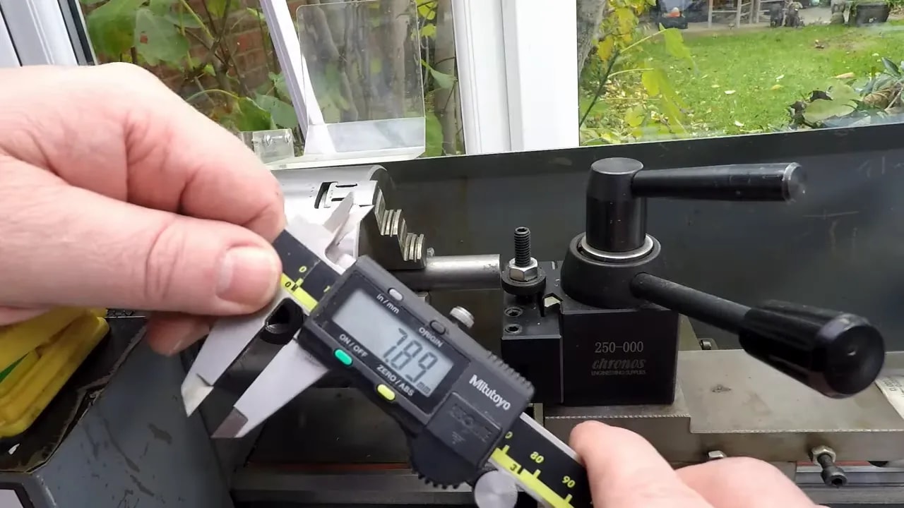 Digital calipers with depth probe measuring tool height on a lathe