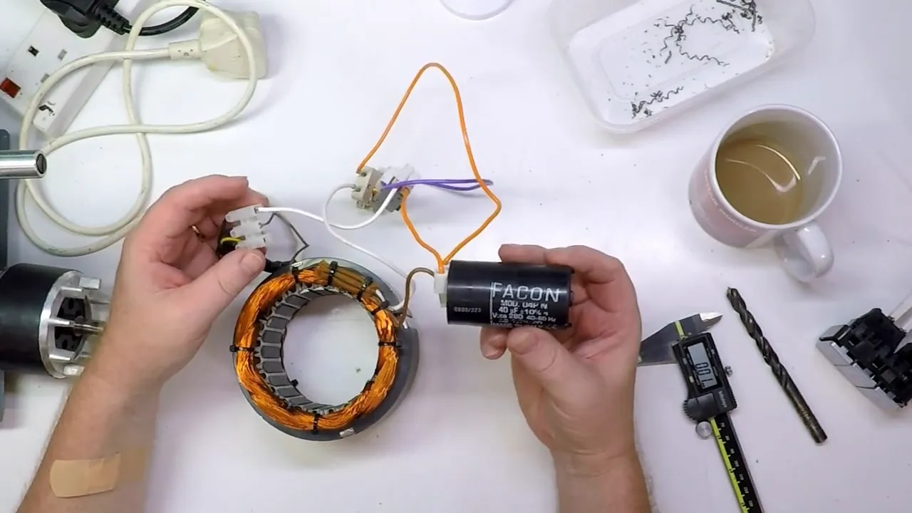 Motor stator coil with the salvaged start capacitor connected for series current limiting in a tool demagnetiser