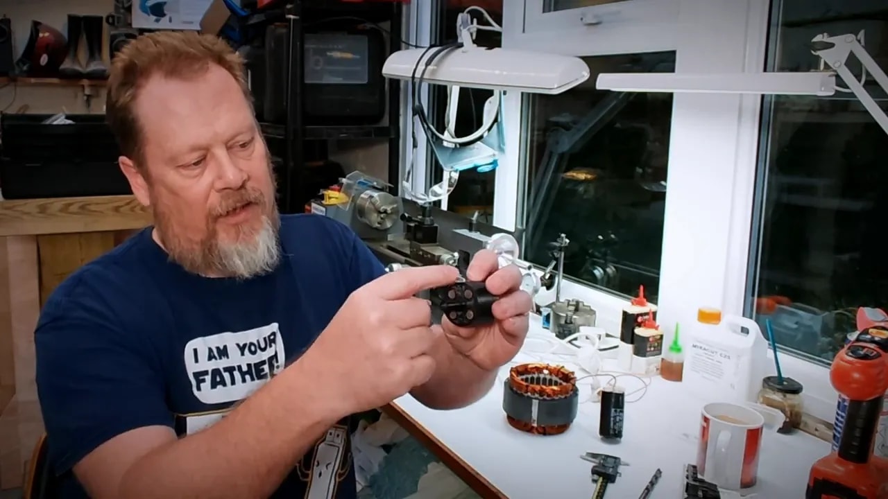 Close-up of the creator holding a component removed from an old food mixer motor during a tool demagnetizer build