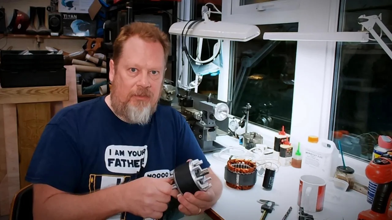 Presenter holding the food mixer motor stator while discussing the overheating problem