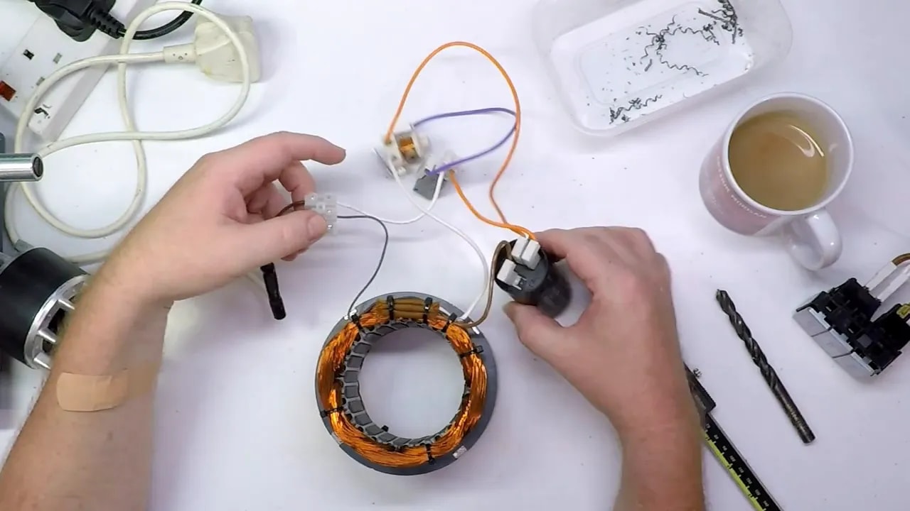 Hands wiring a single-phase induction motor stator coil with run and start circuit leads