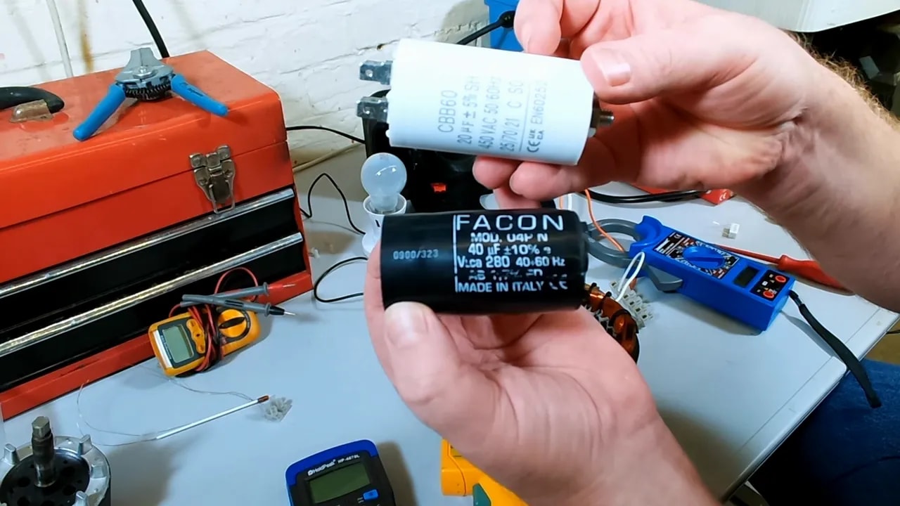 Two capacitors held up close to camera showing labels and different sizes
