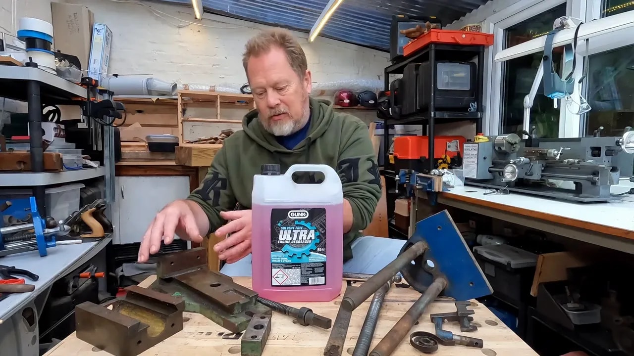 Gunk Ultra container on a workbench surrounded by dismantled vice parts