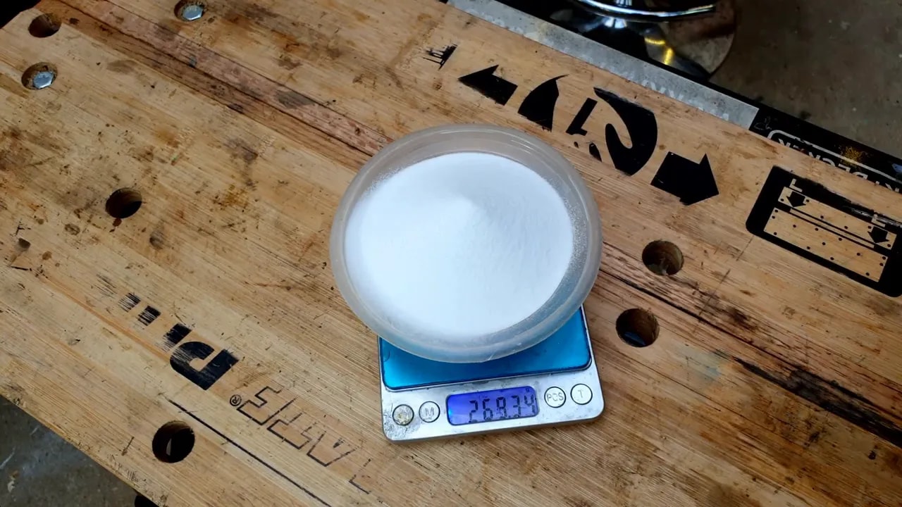 Container of white Deox-C powder sitting on a digital scale